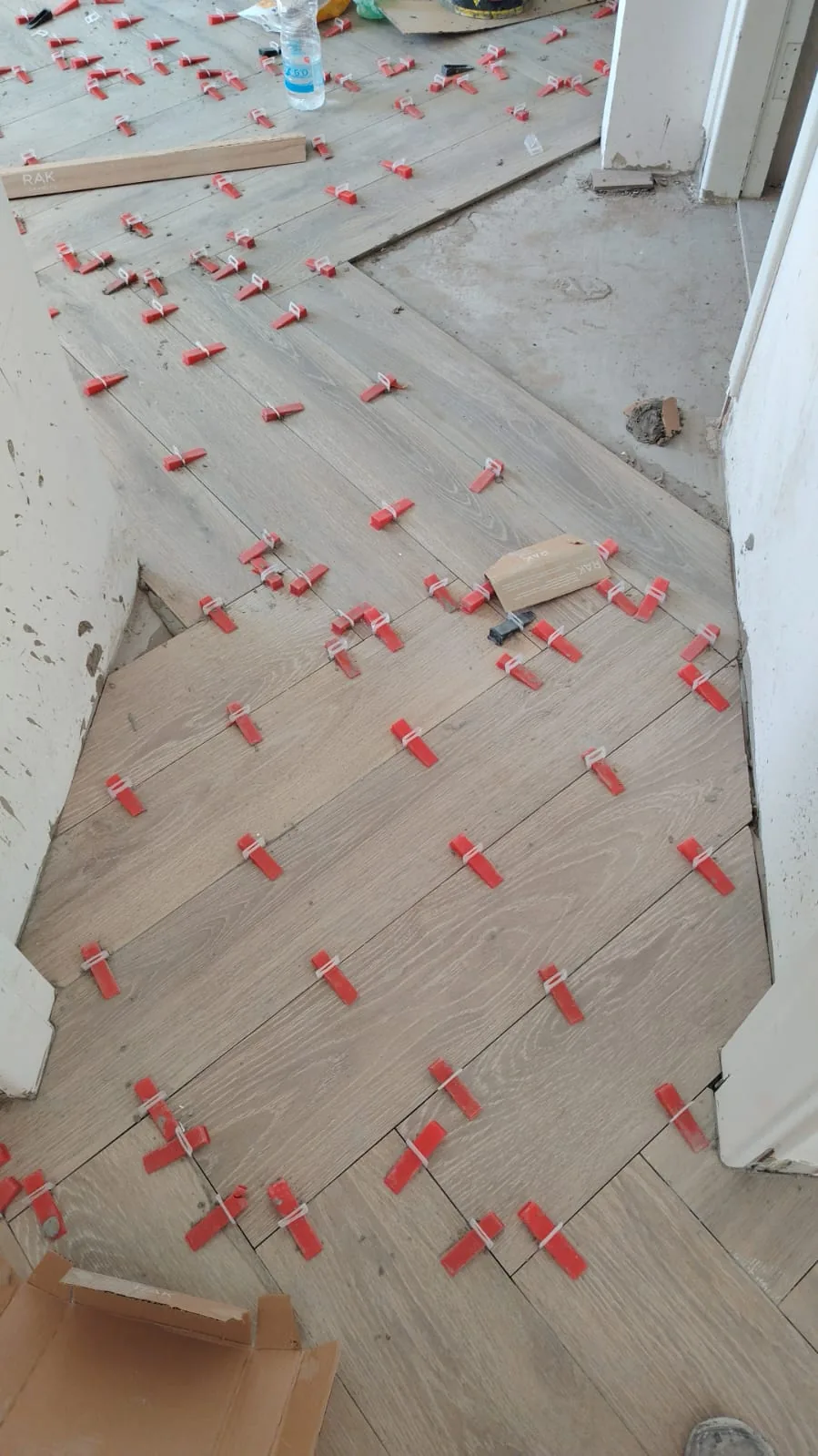 Floor tiles set with red levelling spacers